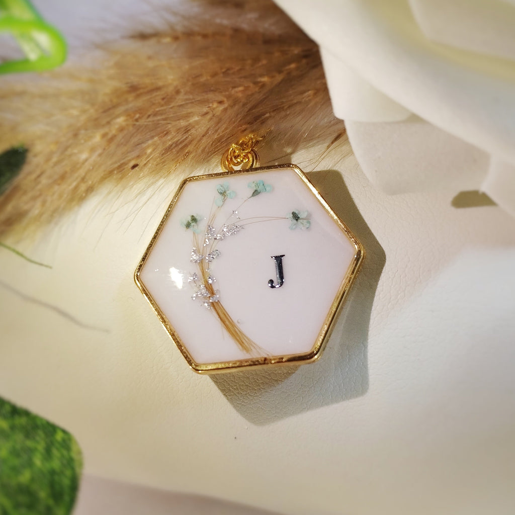 Bijou de forme hexagonale, en acier inoxydable , lait maternel et mèche de cheveux d'enfant.