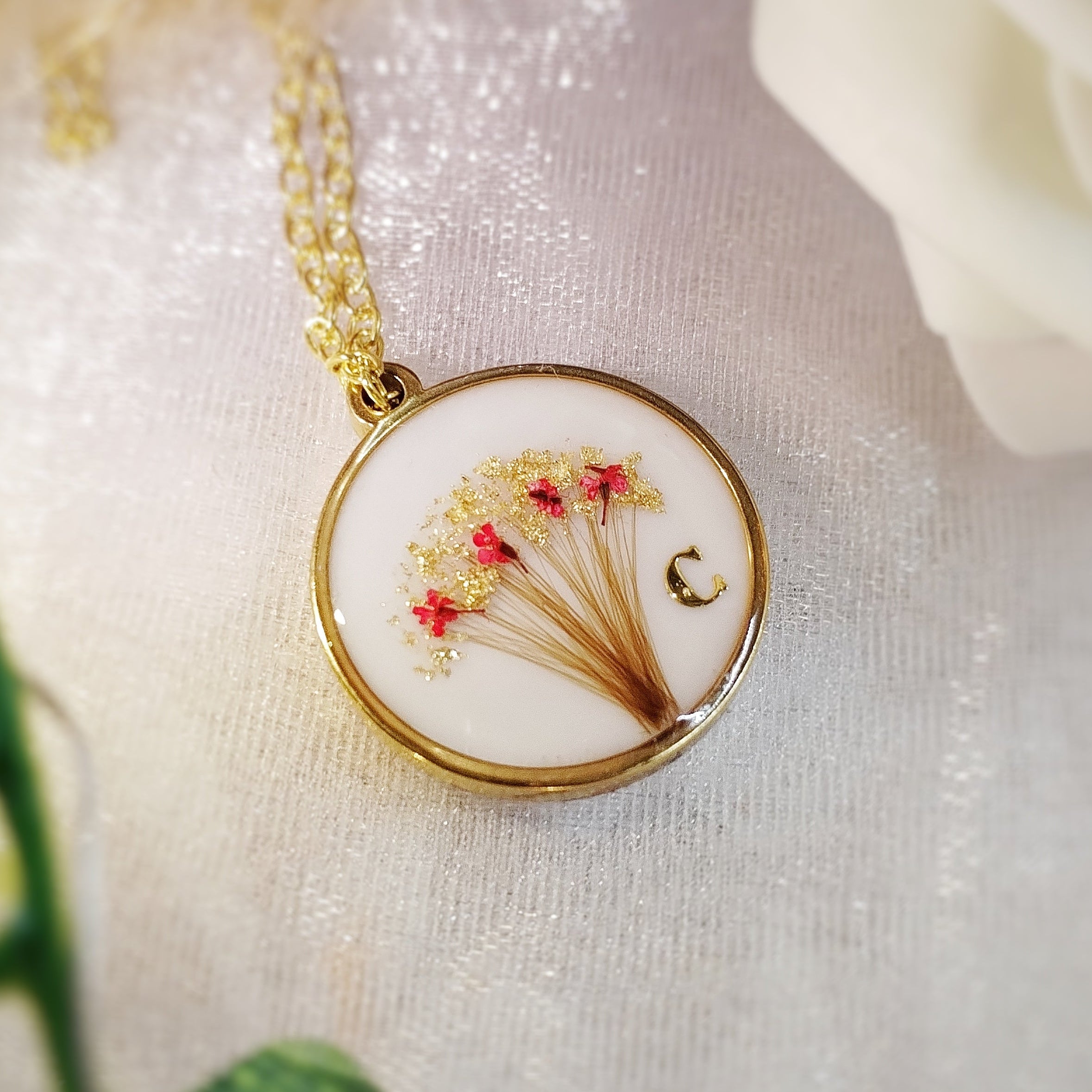 Bijou de forme ronde, en acier inoxydable , lait maternel et mèche de cheveux d'enfant.