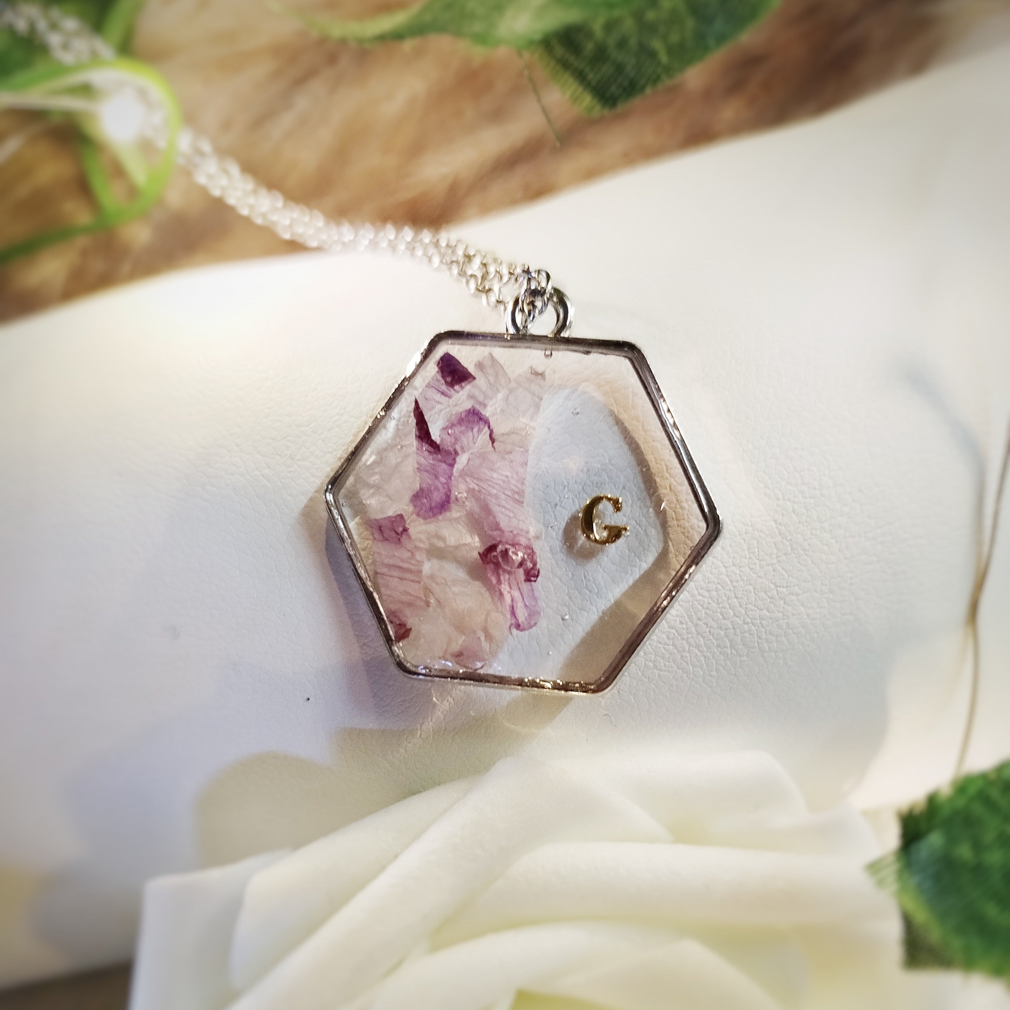 Bijou en acier inoxydable, résine, fleurs de naissance ou de cérémonie en inclusion dans la résine.