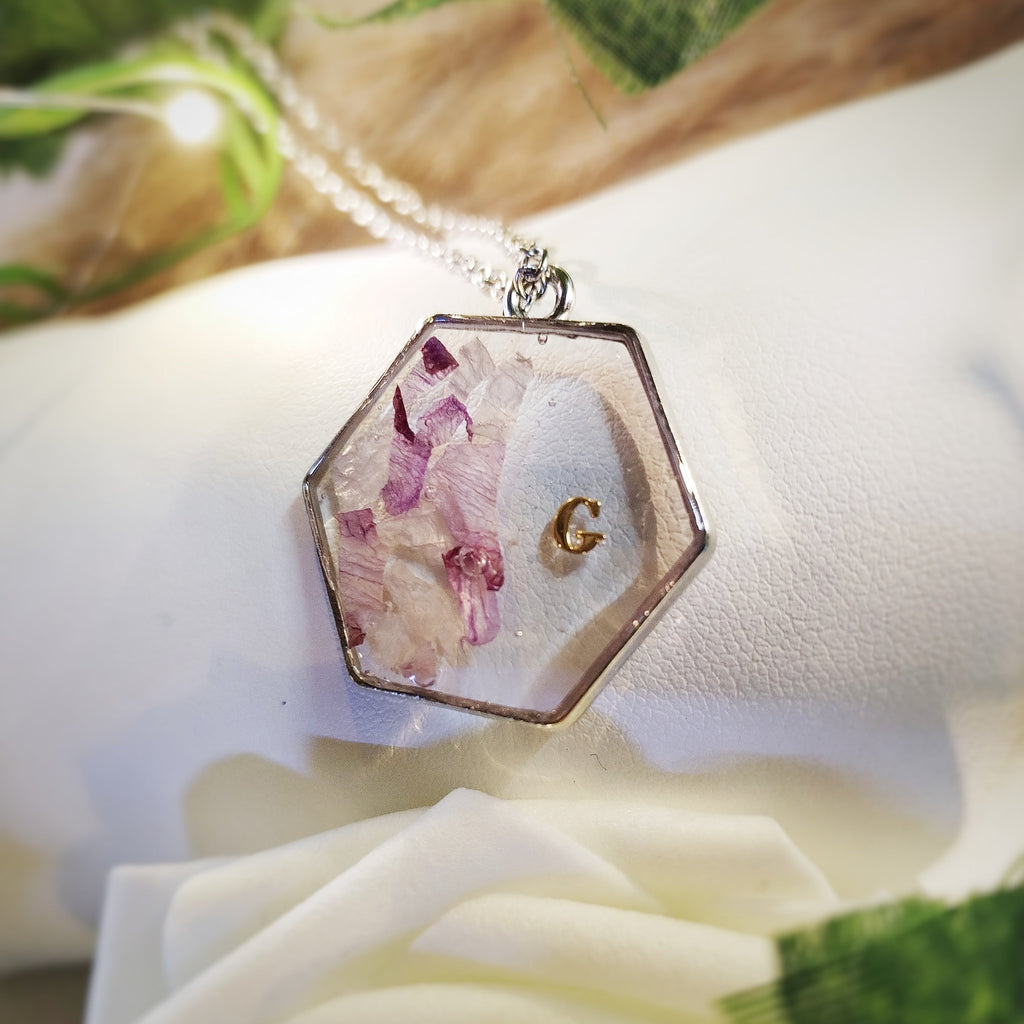 Bijou en acier inoxydable, résine, fleurs de naissance ou de cérémonie en inclusion dans la résine.