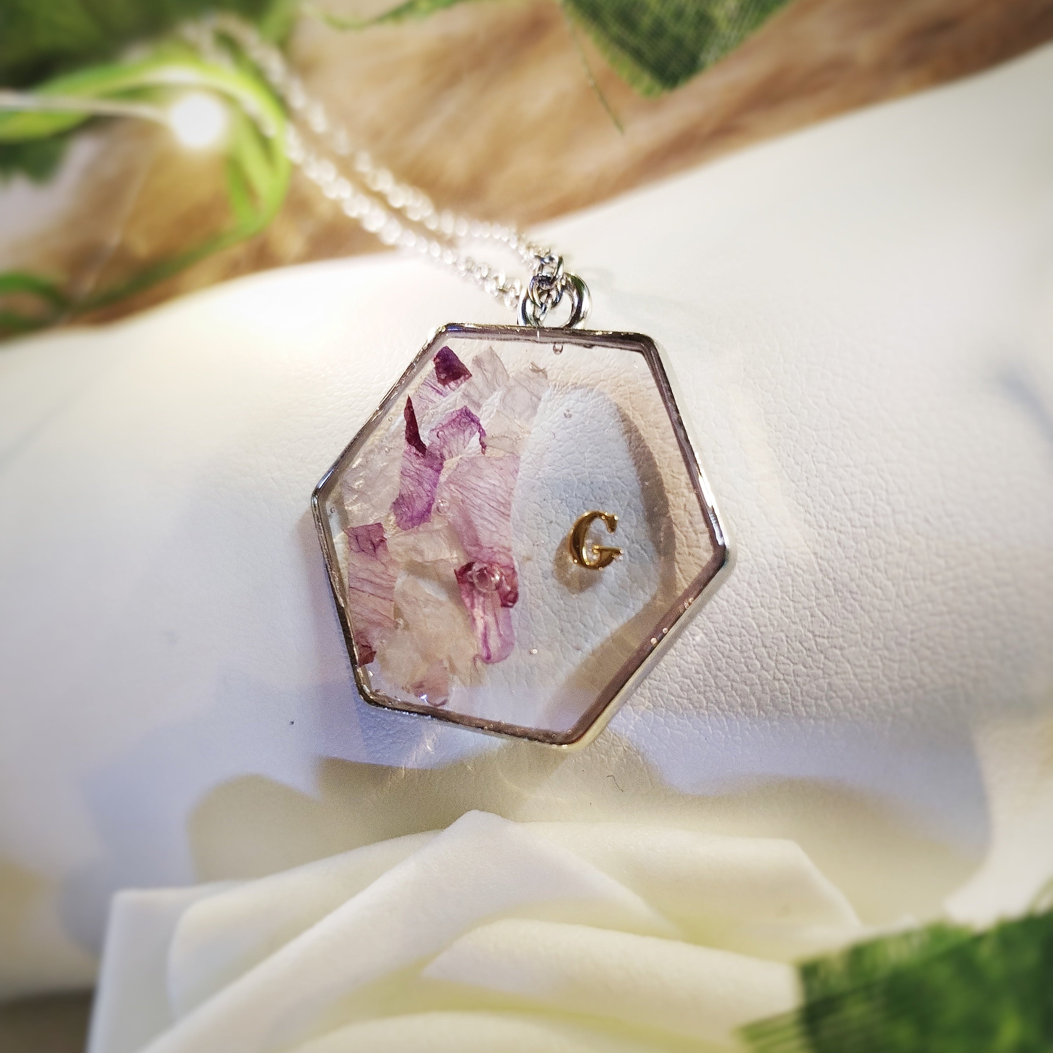 Bijou en acier inoxydable, résine, fleurs de naissance ou de cérémonie en inclusion dans la résine.
