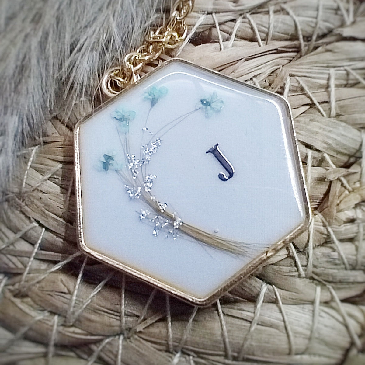 Bijou de forme hexagonale, en acier inoxydable , lait maternel et mèche de cheveux d'enfant.