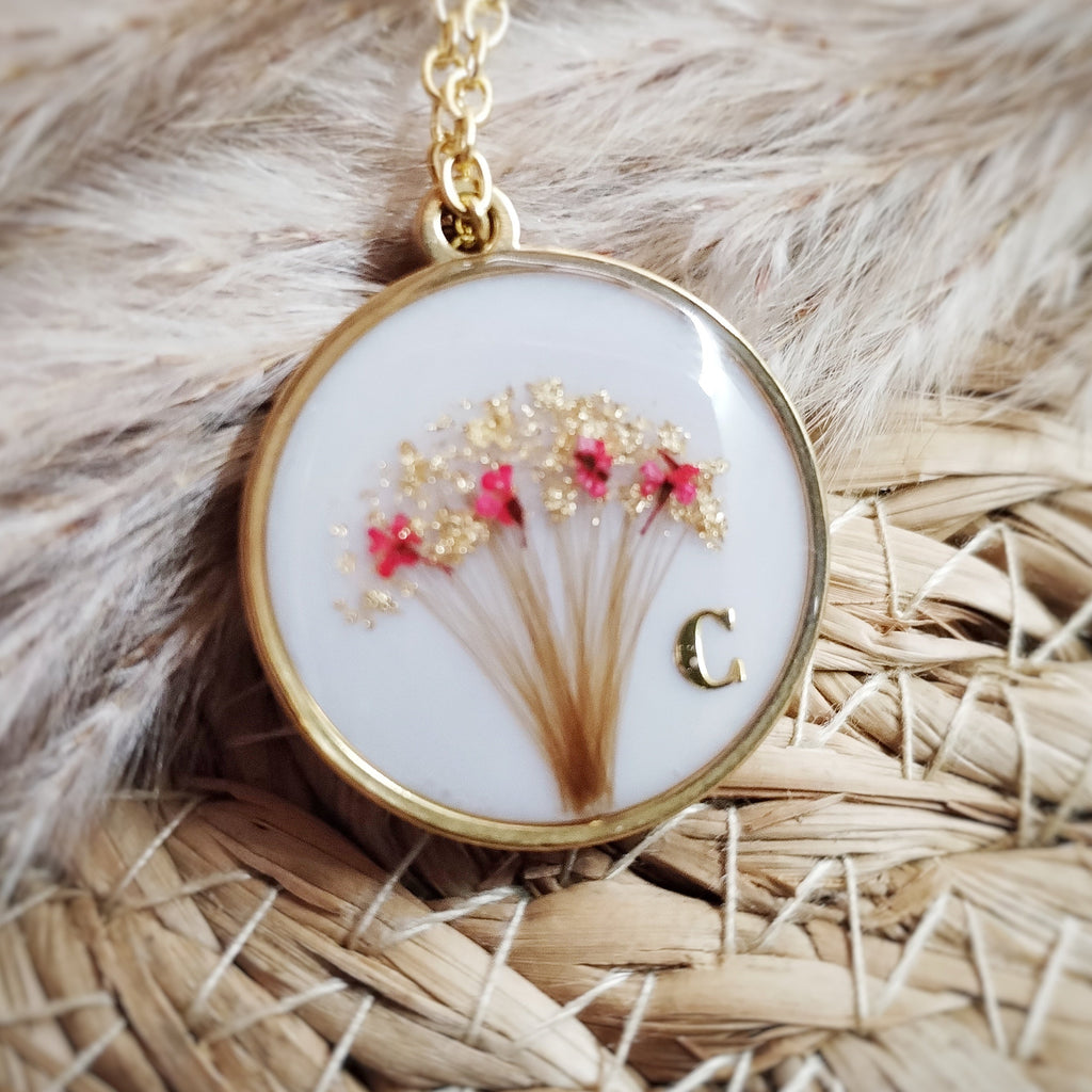 Bijou de forme ronde, en acier inoxydable , lait maternel et mèche de cheveux d'enfant.