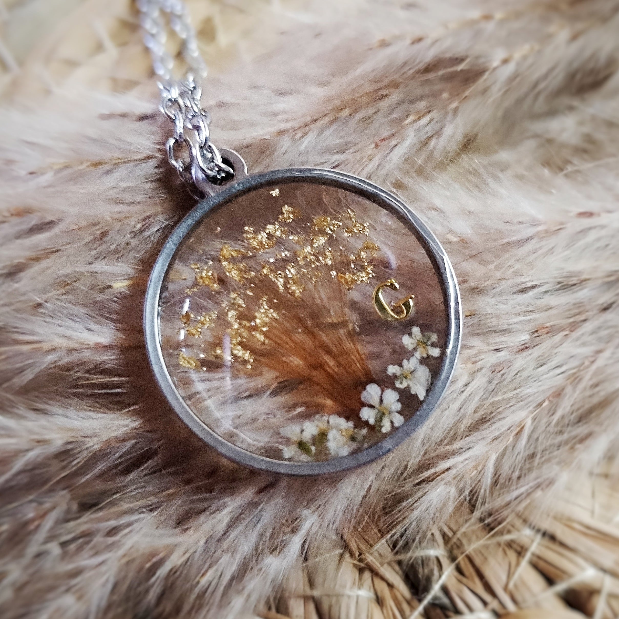 Bracelet en acier inoxydable, mèche de cheveux, lait maternel, poils et/ou cendres d'animaux en inclusion dans la résine.